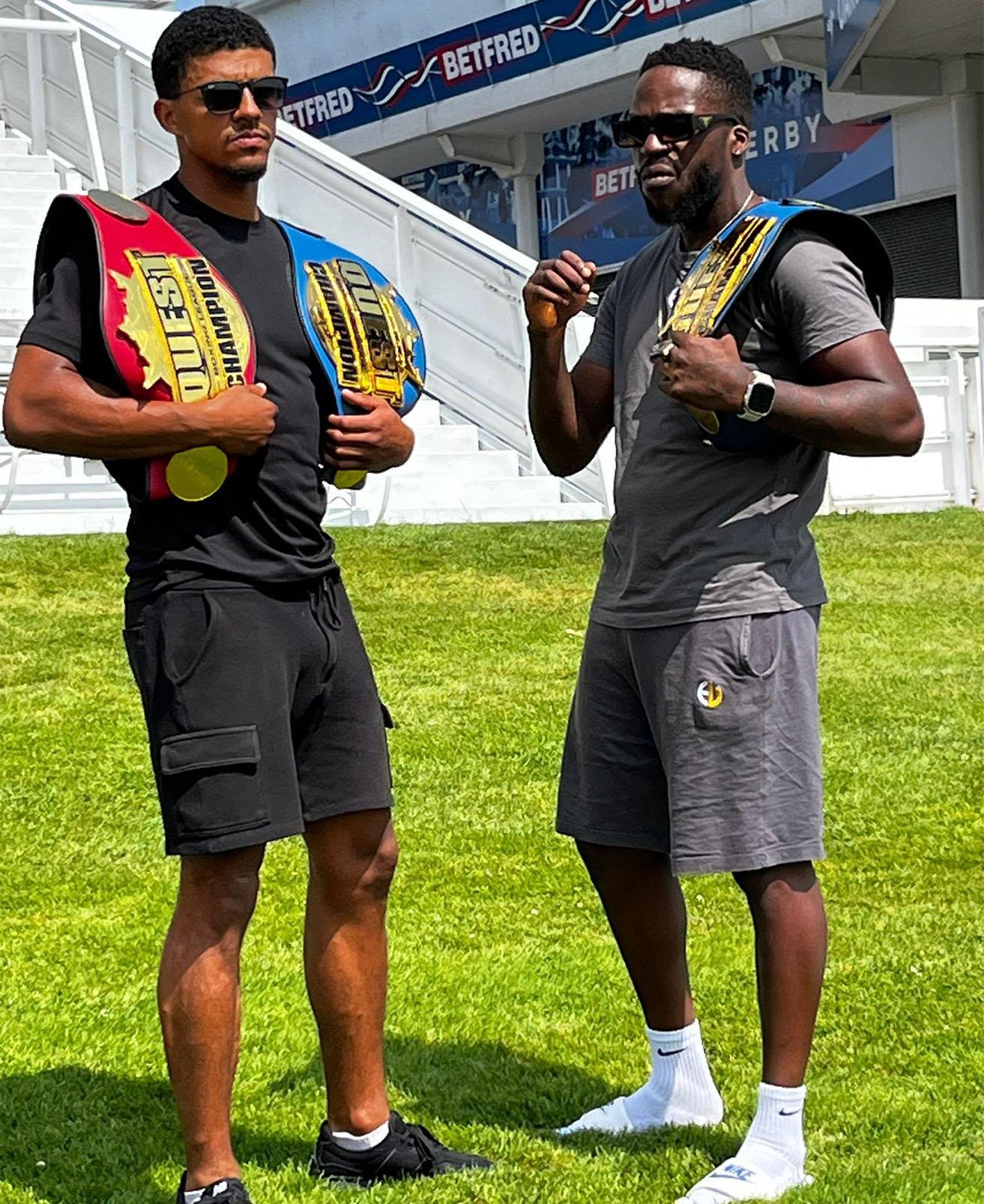 Team Shumba boxers holding championship belts in sponsorship photo