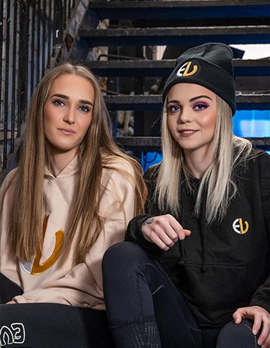 EV Logo Beanie Hat_ EV Clothing black beanies with embroidered logo styled by two women