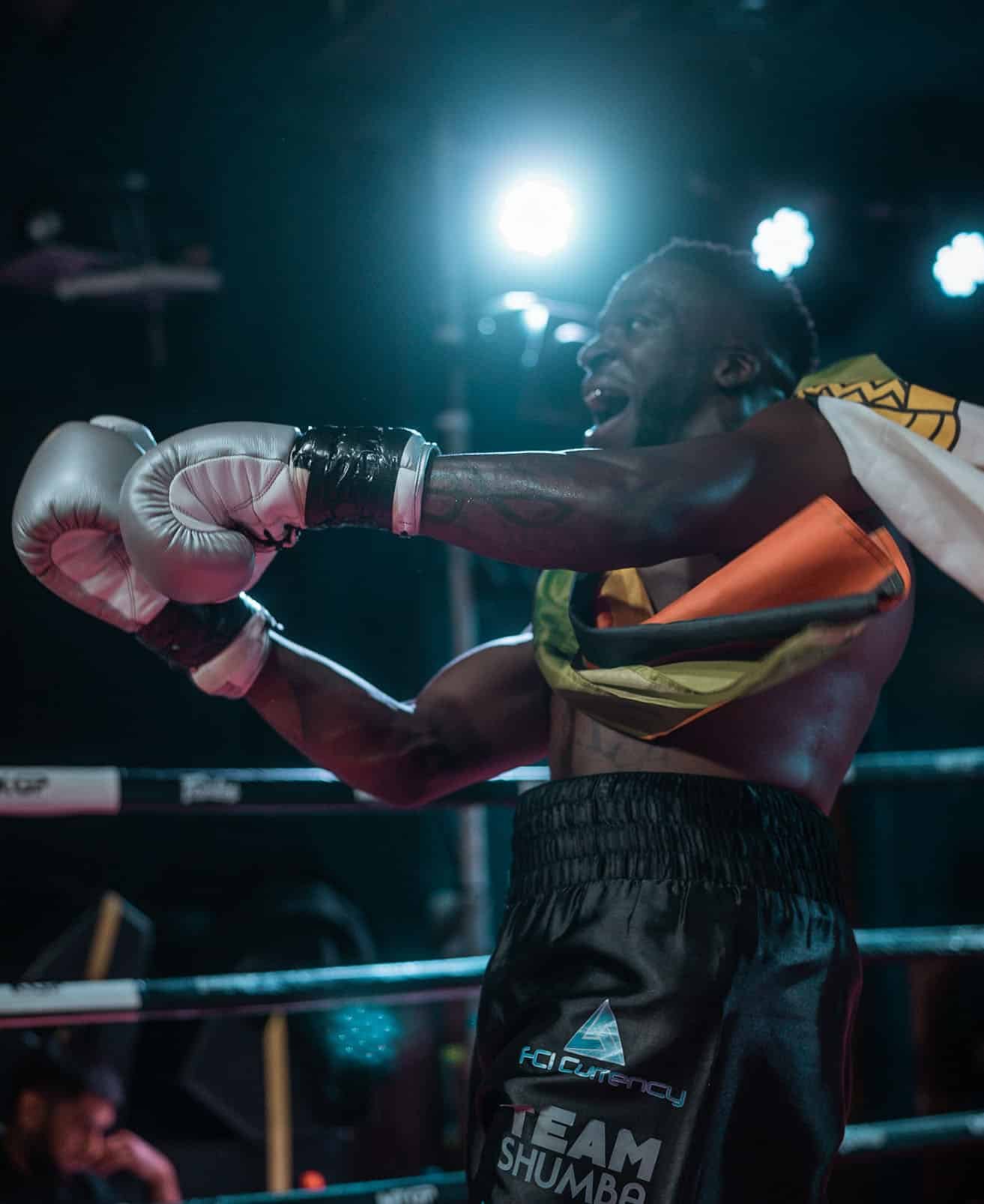 Team Shumba champion boxer raises arm with belt in the ring
