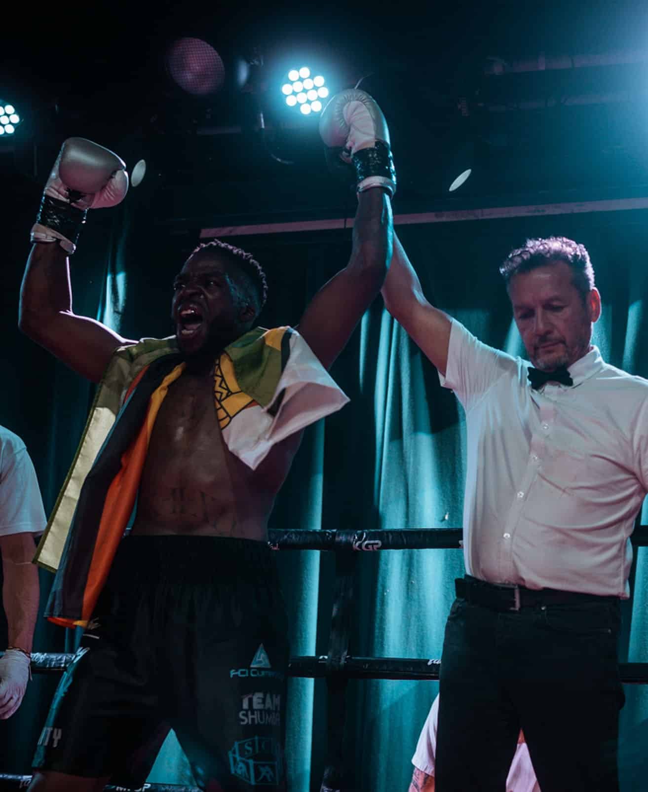 Team Shumba boxer celebrates victory with referee raising his hand